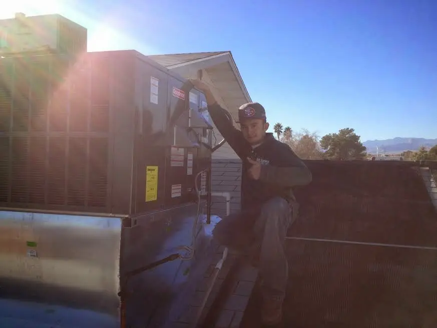 HVAC technician performing AC Tune-Up on a rooftop unit in North Adams